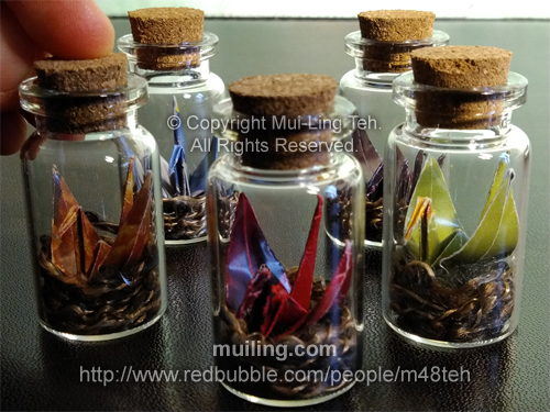 Colourful bottled origami cranes sitting in nests by Mui-Ling Teh